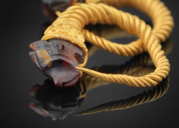 Detail of gold earrings with inset heads of wolves made of semi-precious stones from the excavations of the Thessaloniki Metro ©EFAPOTH