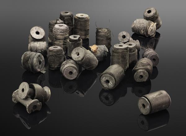 Composition of charred sewing machine bobbins unearthed from an underground storeroom. The photo is included in the Thessaloniki Metro photo album for 2018. ©EFAPOTH